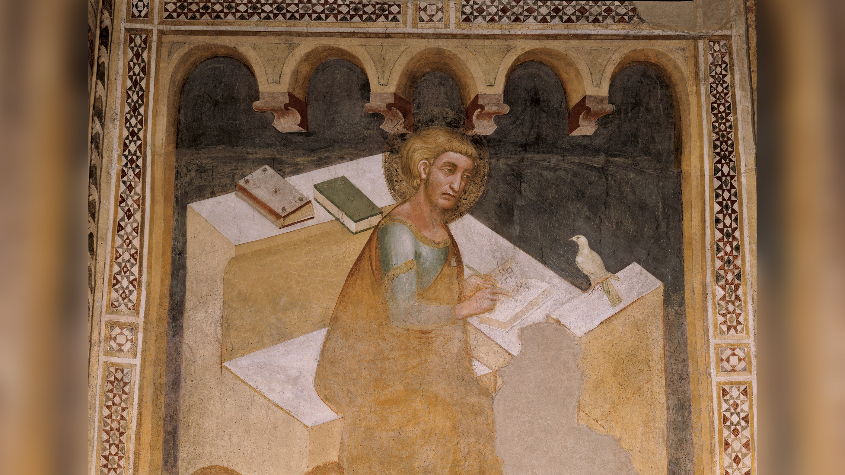 Representation of the evangelist Saint Mark while is absorbed in writing the Gospel; in front of him, a dove, symbol of peace.