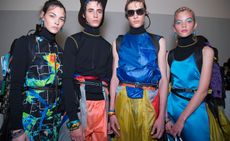 4 models stood together in a studio wearing brightly coloured clothing