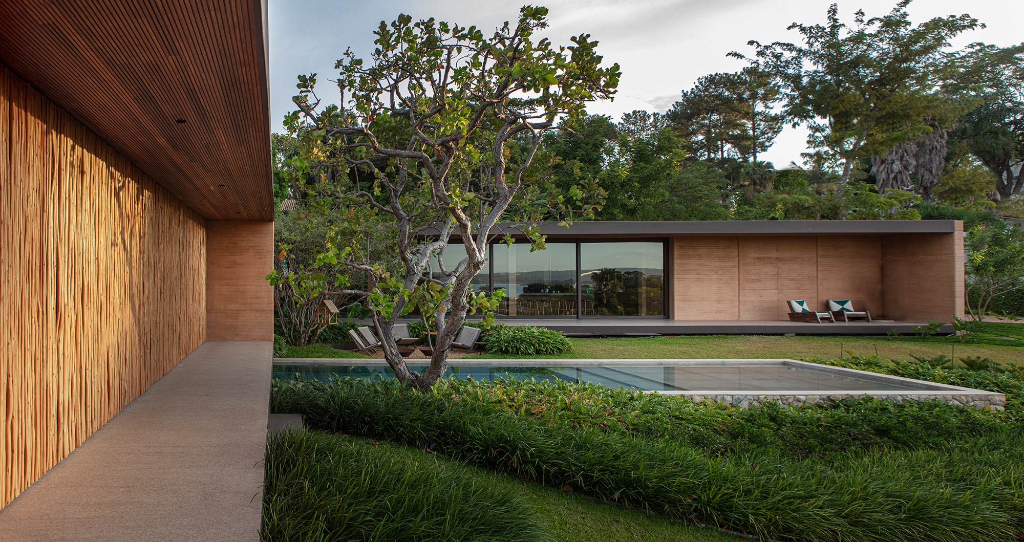 View from the bedroom wing across the pool to the main living area and long veranda