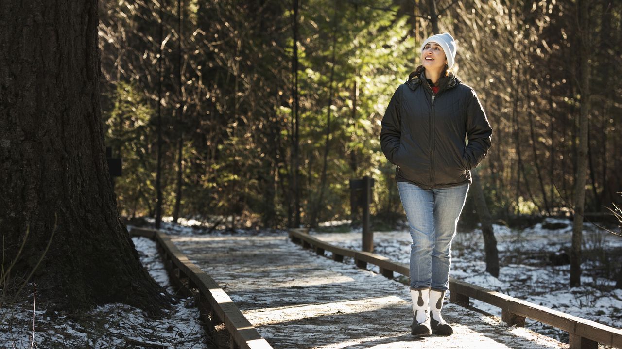 Alternative New Year&#039;s resolutions: Image shows woman walking in wintery forest