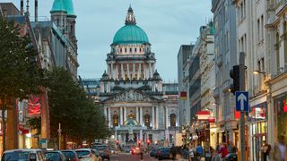 Belfast city center pictured at dusk with town hall in distance.