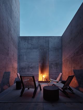 red rock house exterior of patio with seating at dusk