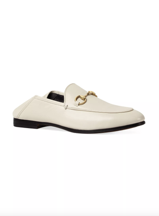a pair of gucci loafers on a plain white backdrop