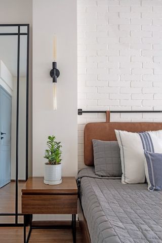 A white bedroom with a brick wall