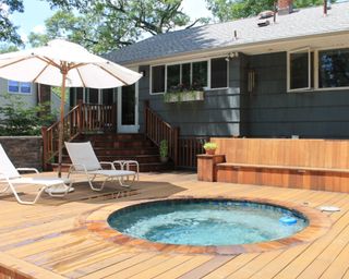 A small round pool surrounded by natural decking