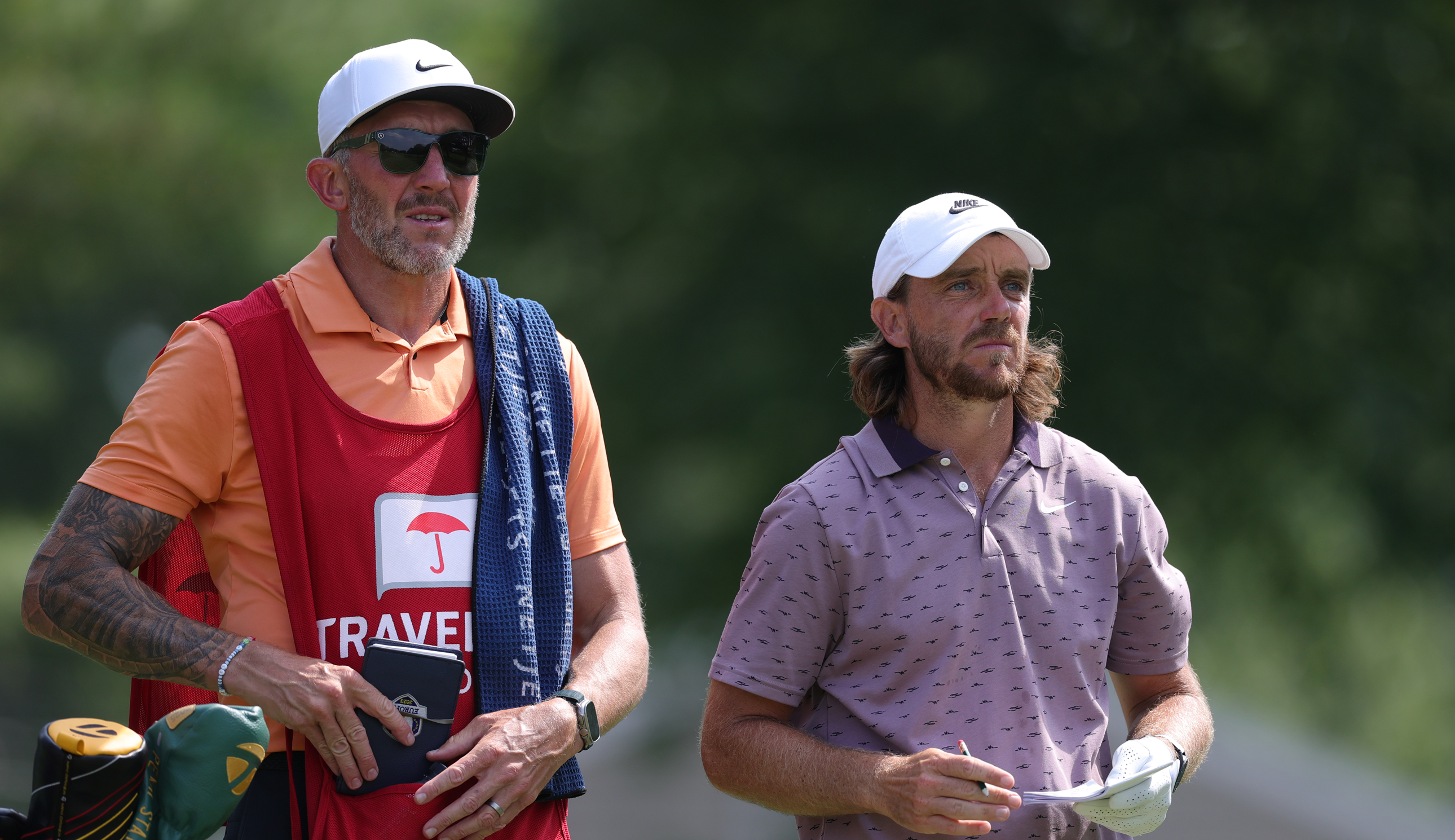 Tommy Fleetwood stands next to his caddie