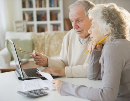 Senior couple using laptop and discussing bills