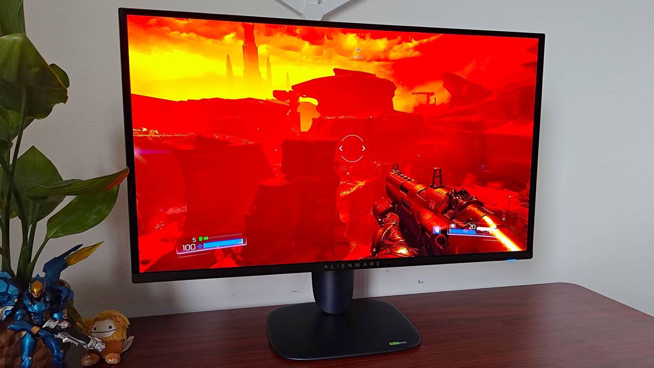 Alienware AW2725Q gaming monitor with DOOM gameplay on screen featuring vibrant red view of Mars.