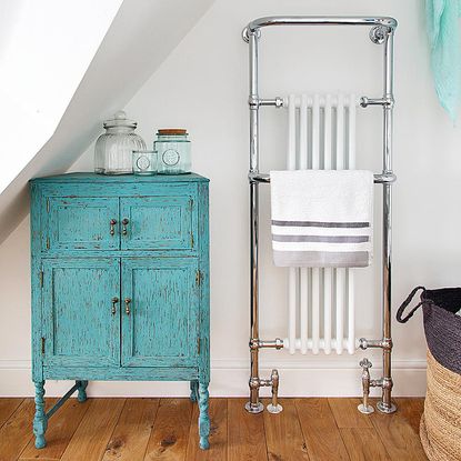 room with blue cupboard wooden flooring and white walls