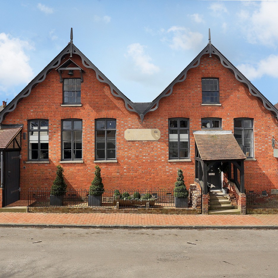 school house with brick wall and shrubs