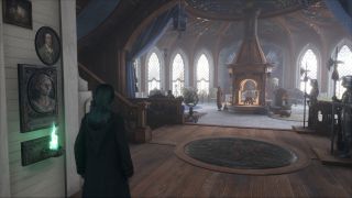 Hogwarts Legacy fast travel - a green glowing Floo Flame is to the left of the character as she looks into the common room.