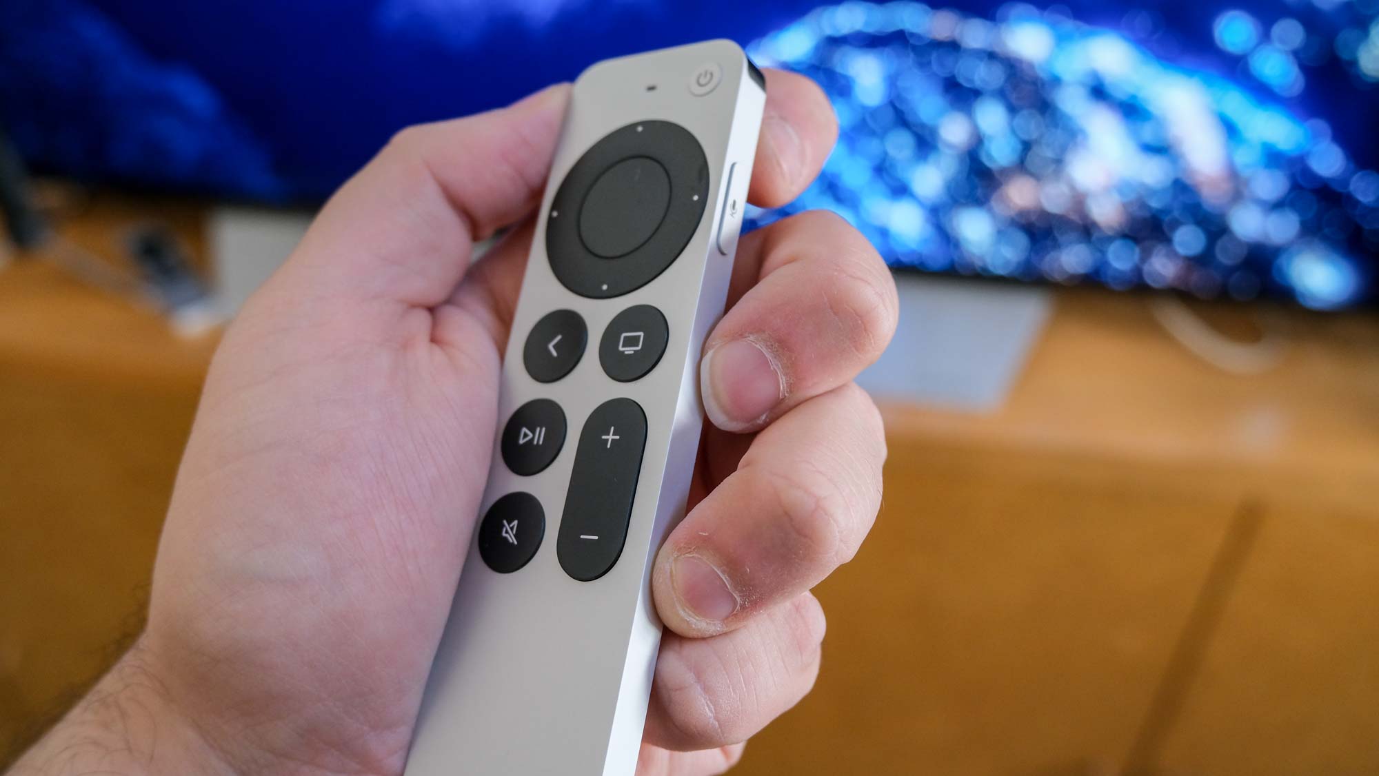 The Apple TV 4K (2022) remote in hand, tilted to the side