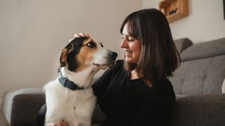 Female dog owner hugging dog and stroking his head