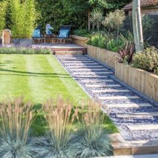 narrow garden with striped lawn and pathway
