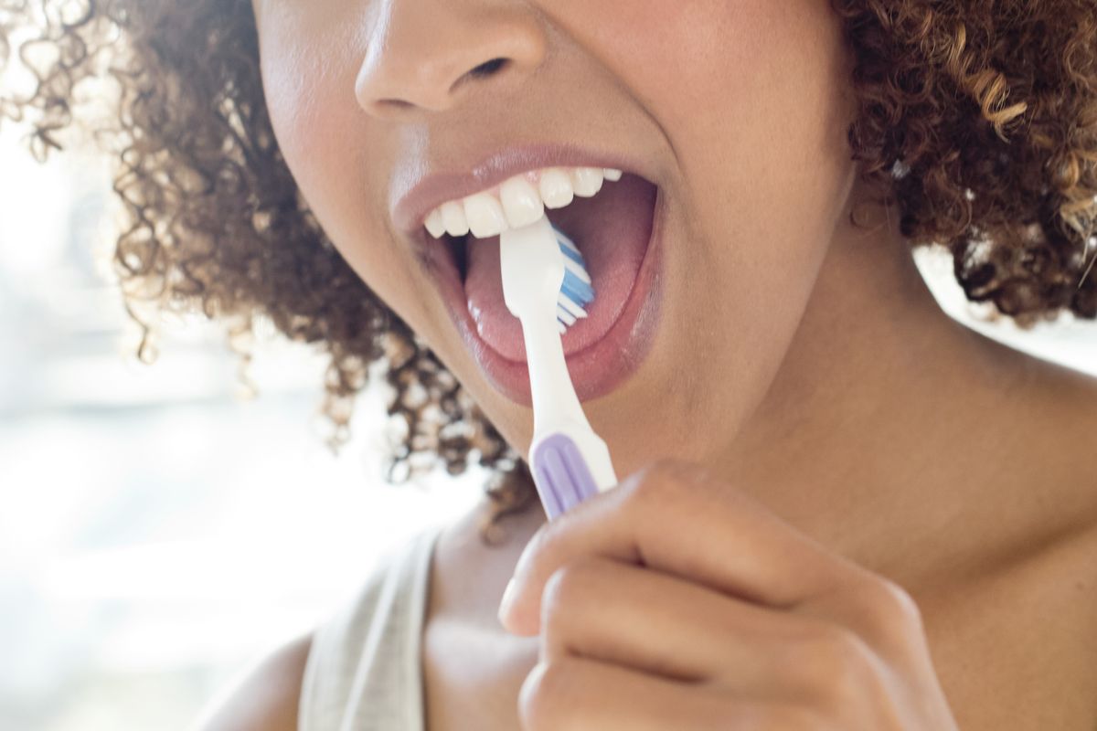 Should you brush your tongue: image of woman brushing tongue