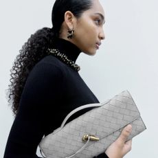 A model carrying a NET-A-PORTER bag.