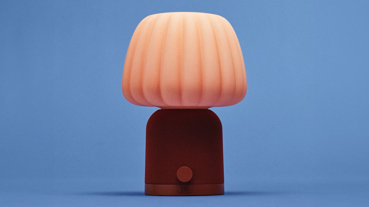 En oransje IKEA-lampe mot en bl&aring; bakgrunn.