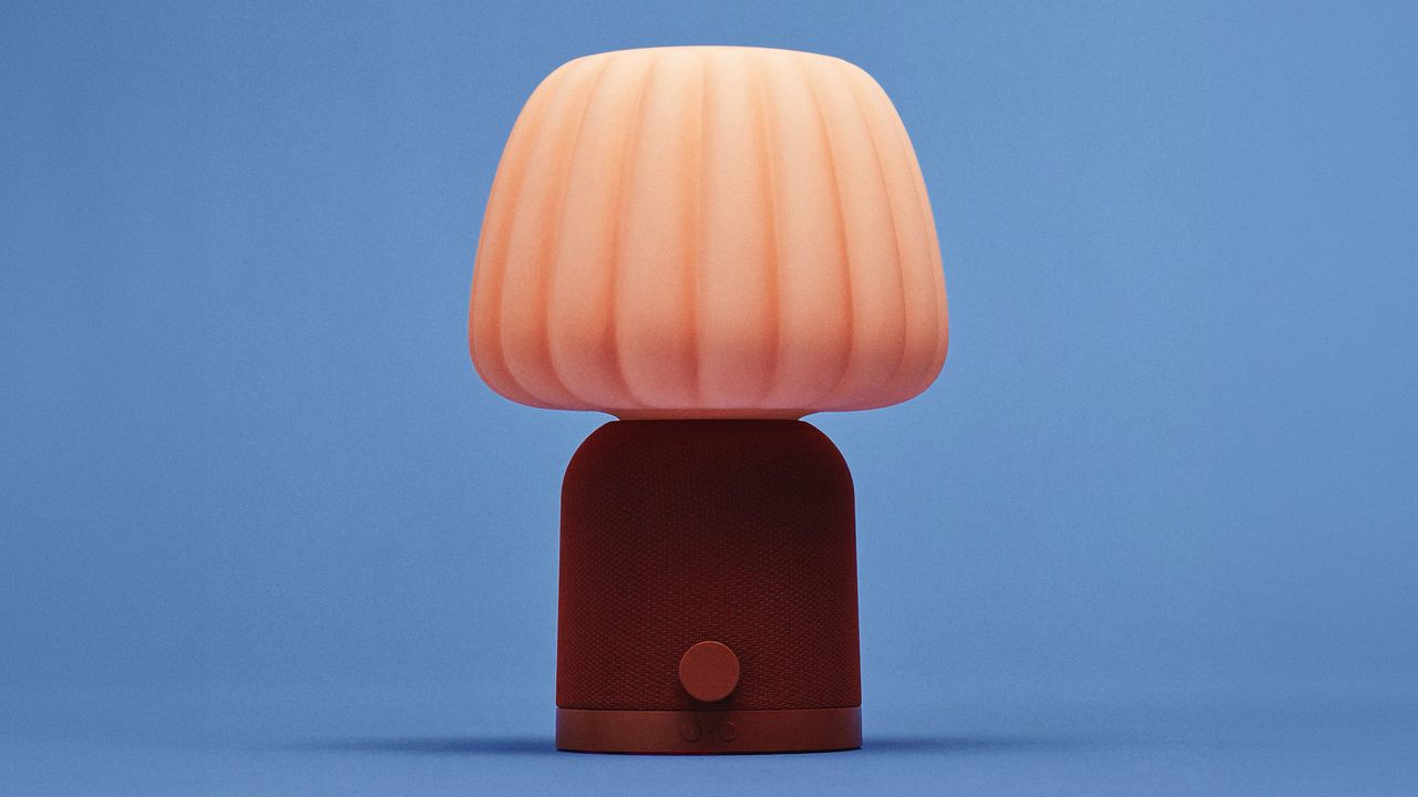 En oransje IKEA-lampe mot en bl&aring; bakgrunn.