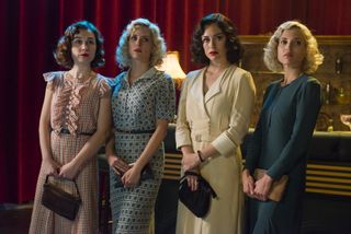 four women in 1920s era clothing standing by a bar in the tv show 'Cable Girls.'