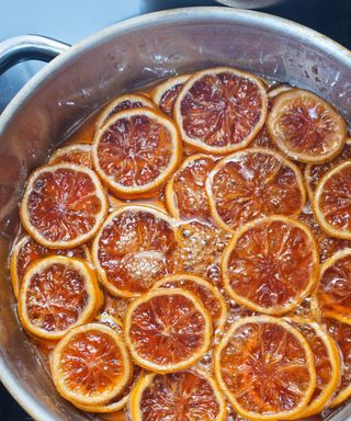 A cooking pot filled with cider and orange slices
