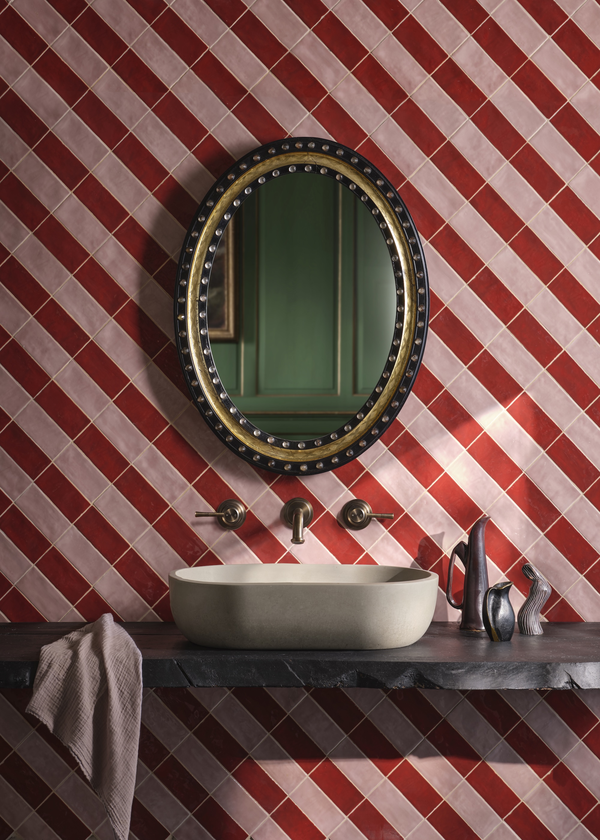pink and red diagonal stripes wall tiles behind a bathroom basin