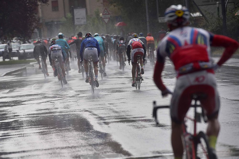 The peloton race through a rain-soaked Lombardy
