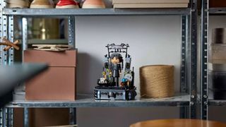 Lego Wednesday Addams Figure on a metallic shelf, next to a spool of string