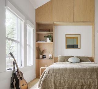 A small bedroom with storage up to the ceiling