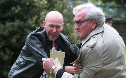 Kevin Vickers tackles a protester.