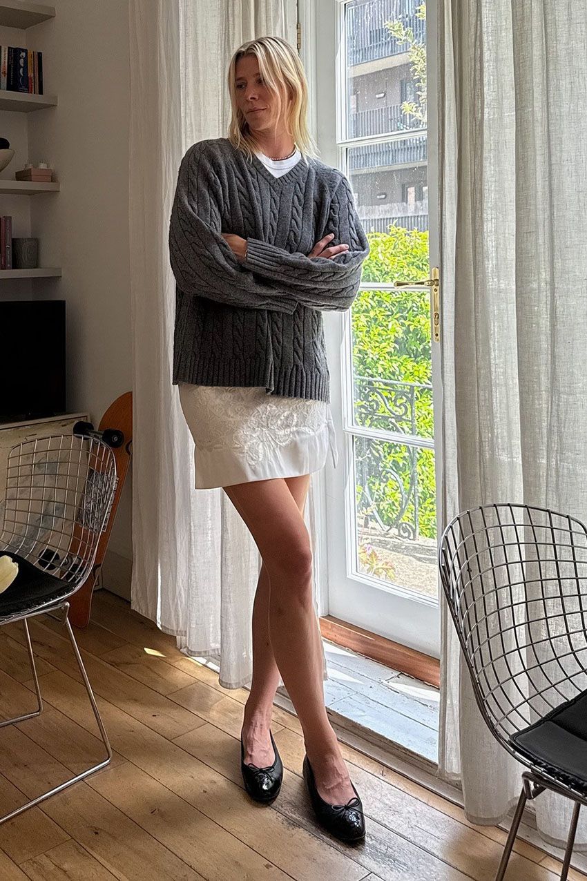 A woman wearing a gray sweater.