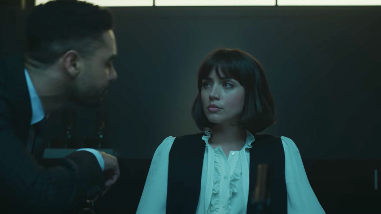 Regé-Jean Page takes a seat to interrogate Ana de Armas in The Gray Man.