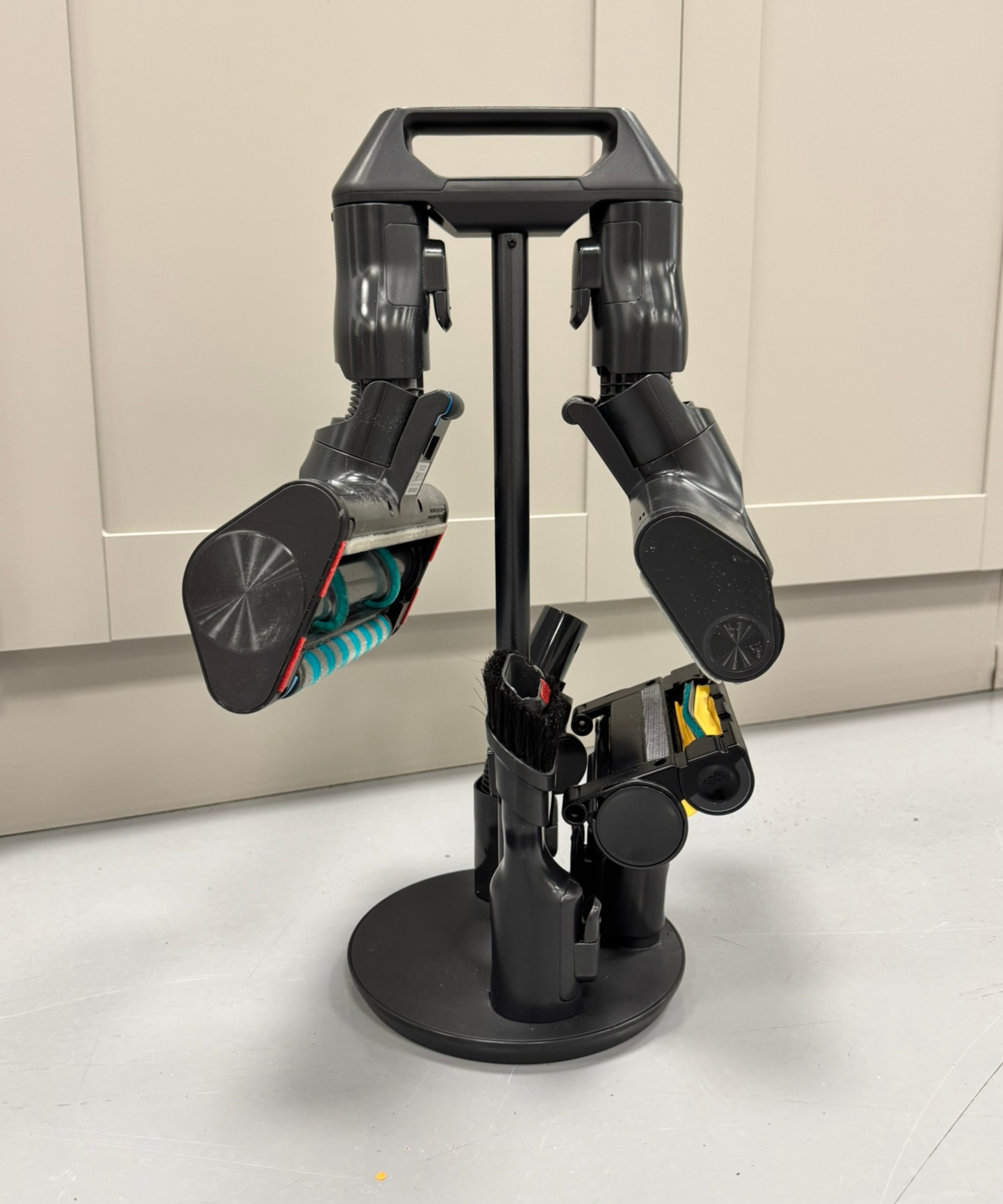 Attachments for the Samsung Bespoke AI Jet Ultra stored in attachment holder, in front of gray cabinets.