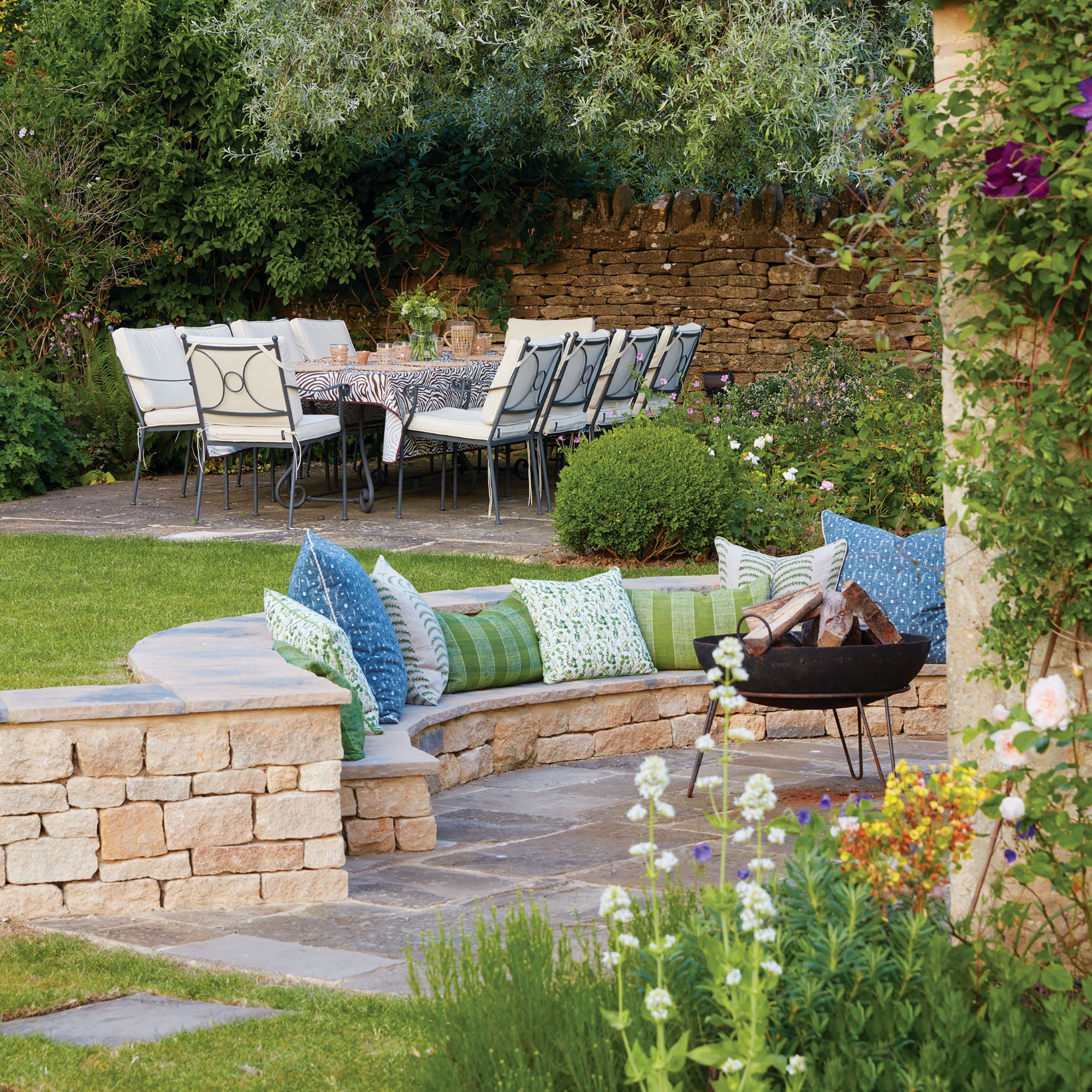 Garden with recessed seating around firepit and large dining table in the back