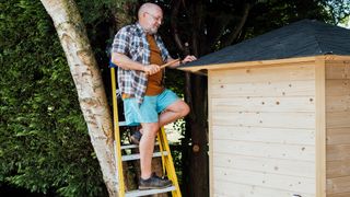 Man fixing a shed roof