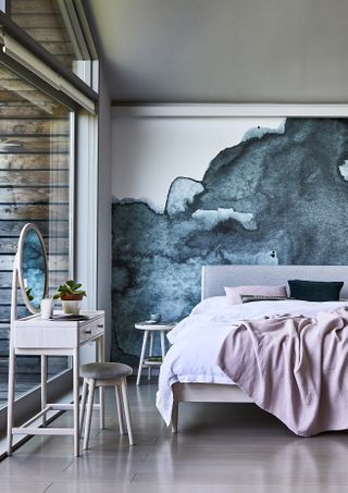 Gray dramatic feature wall in laminate floor room with baby pink dresser and bedding