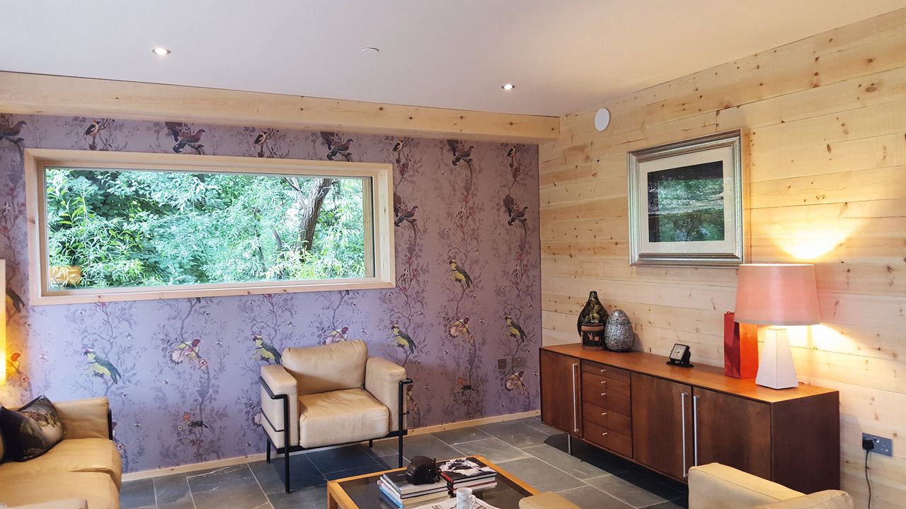 living room with purple wall paper and timber lined windows
