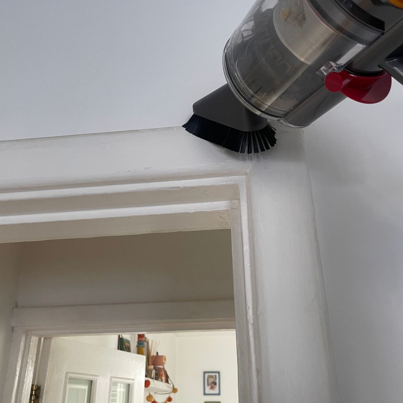 Using the Dyson dusting brush on a white doorframe