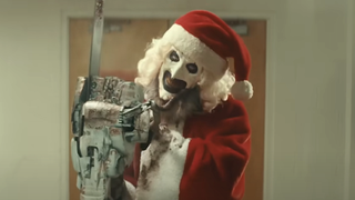 Screenshot of Art the Clown in Santa suit holding a chainsaw in Terrifier 3