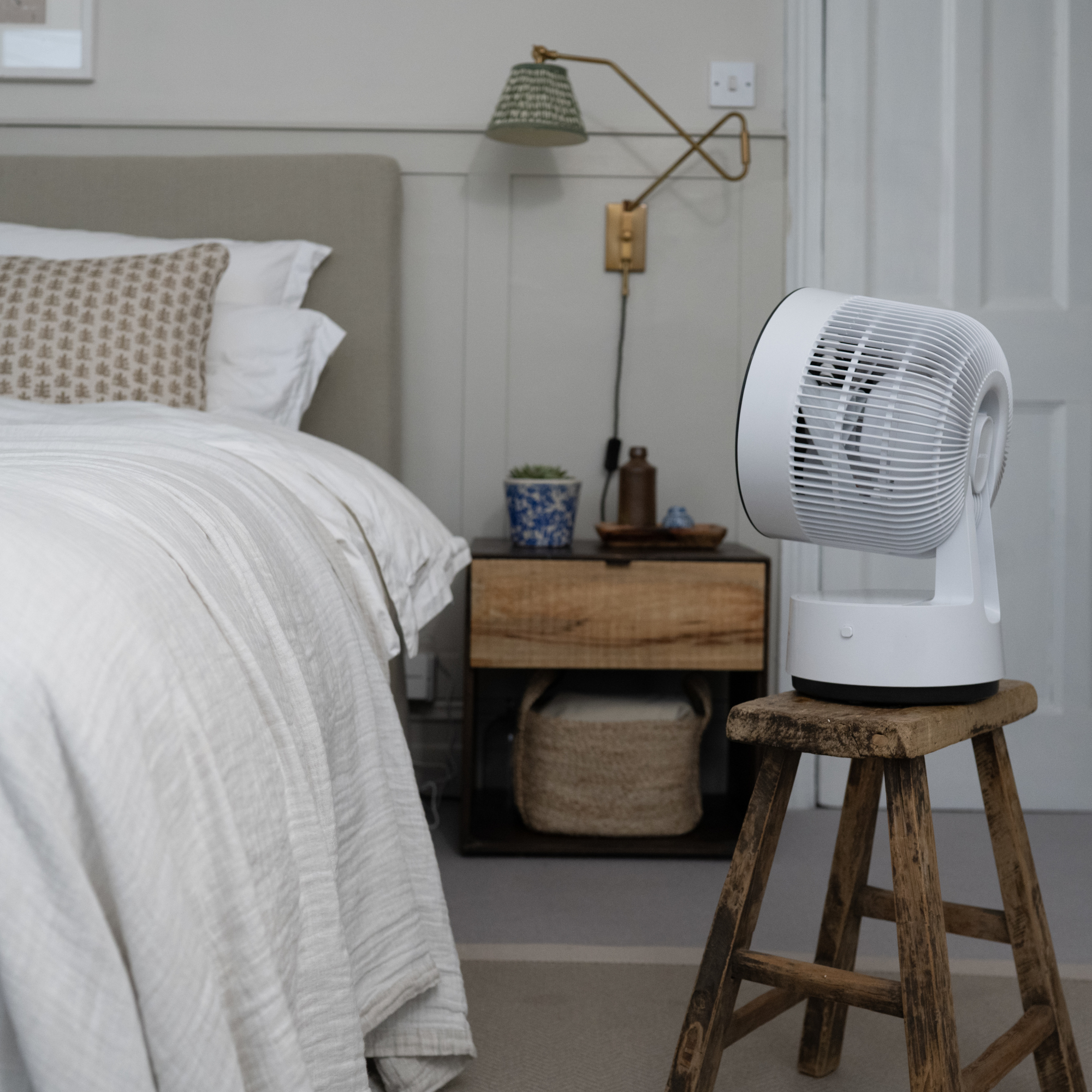 meaco sefte 8 portable fan in a bedroom on a stool by a bed