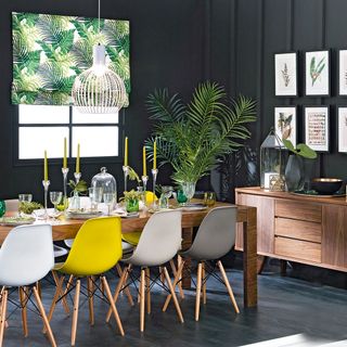 room with black wall yellow chair and wooden dining table