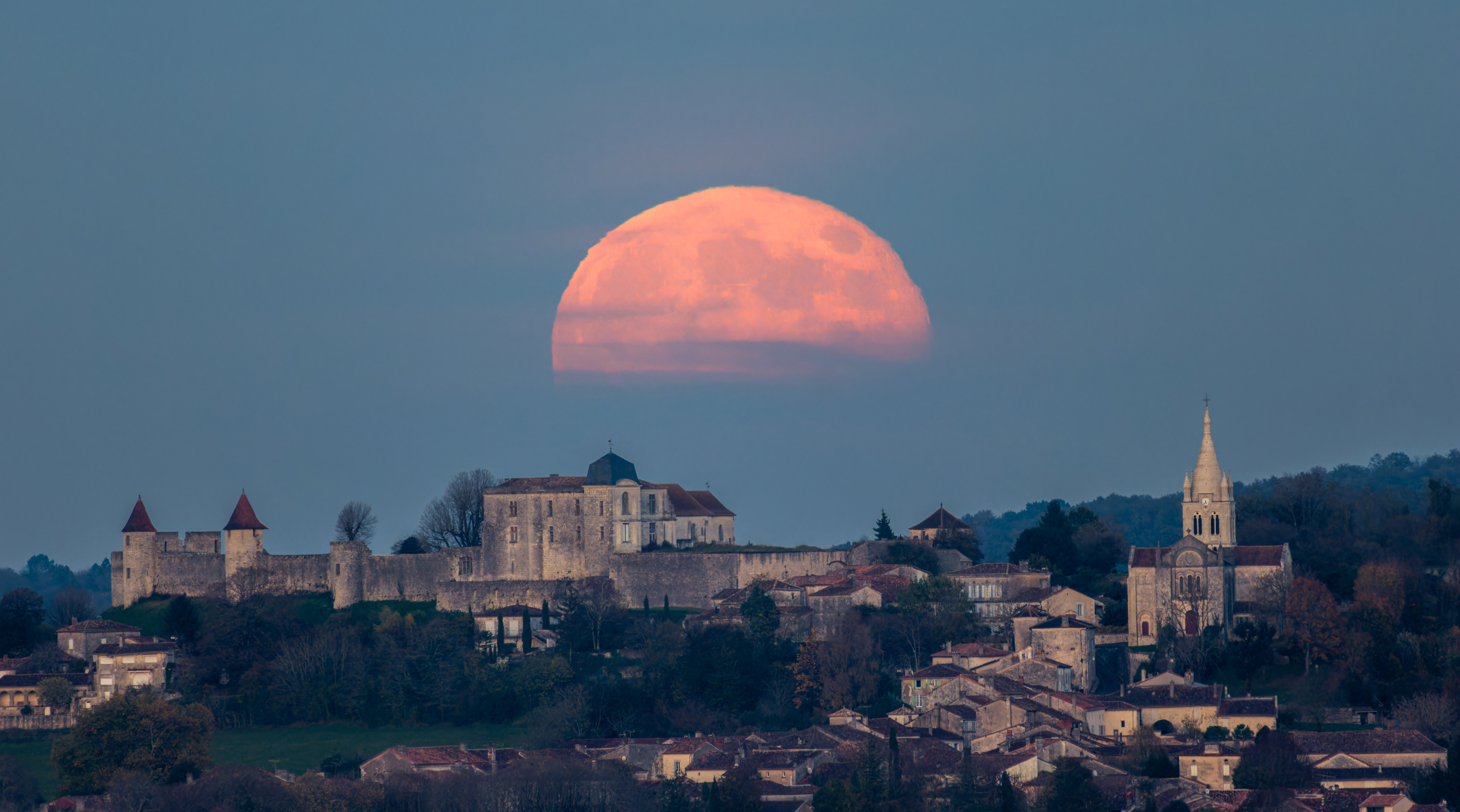 A full red moon hangs low in the night skies over Bordeaux