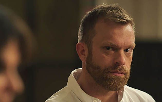 Casualty star William Beck as Dr Dylan Keogh, displaying a rare half-smile