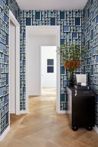a hallway with blue kelly wearstler wallpaper