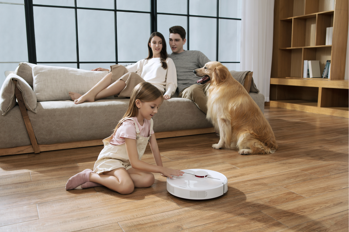 A family surrounding a Dreame D9 vacuum.