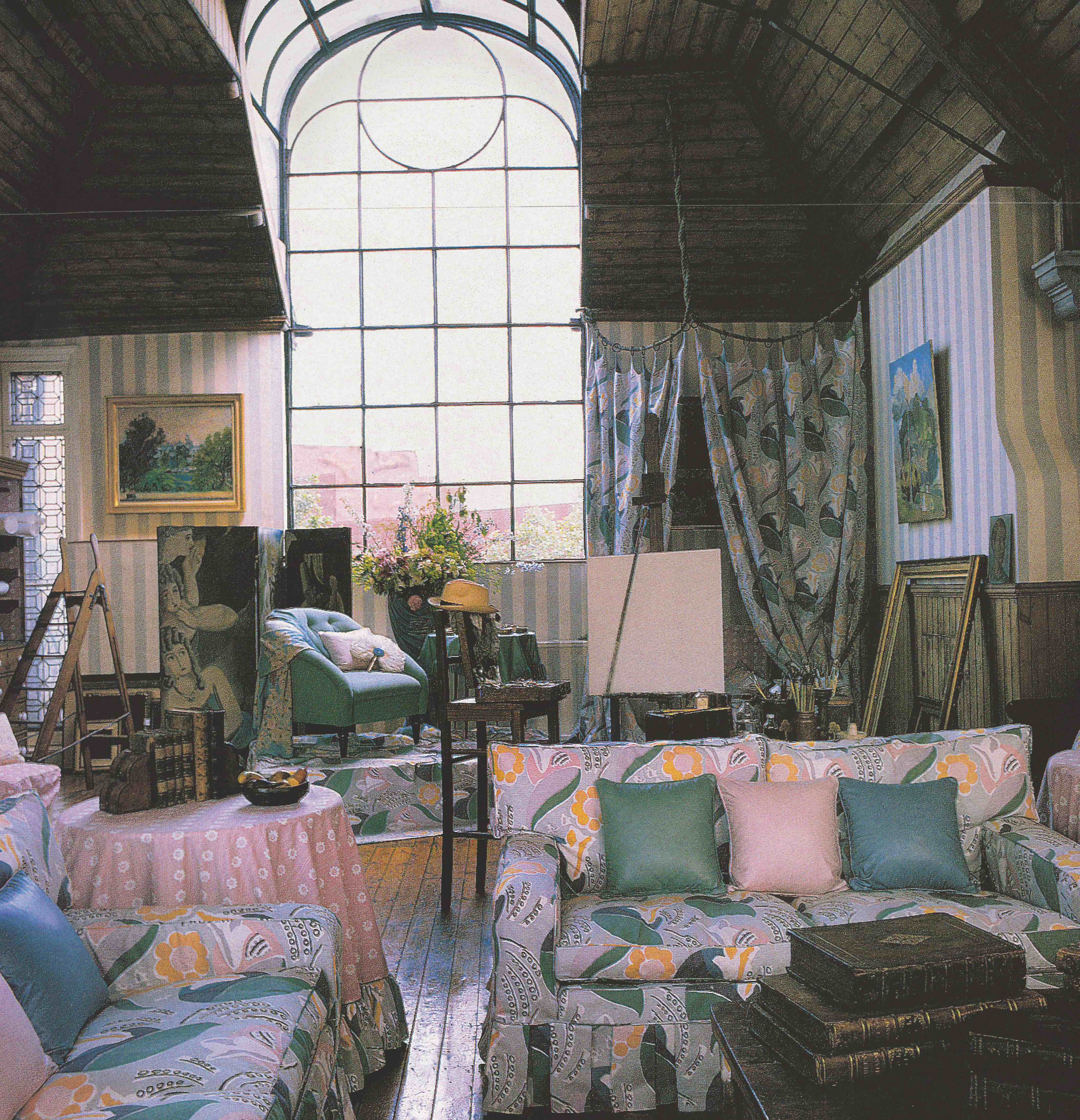 Furniture and drapes made with patterned fabric arranged in an artist studio with a large window