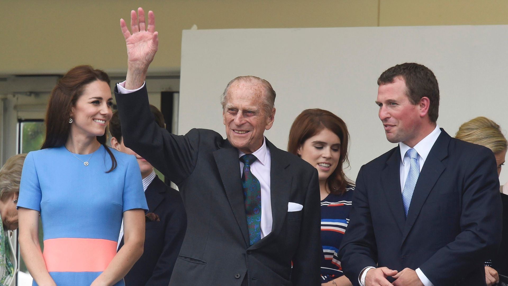 Kate Middleton (L) and Peter Phillips (R) look on as Prince Philip waves to guests on The Mall in 2016
