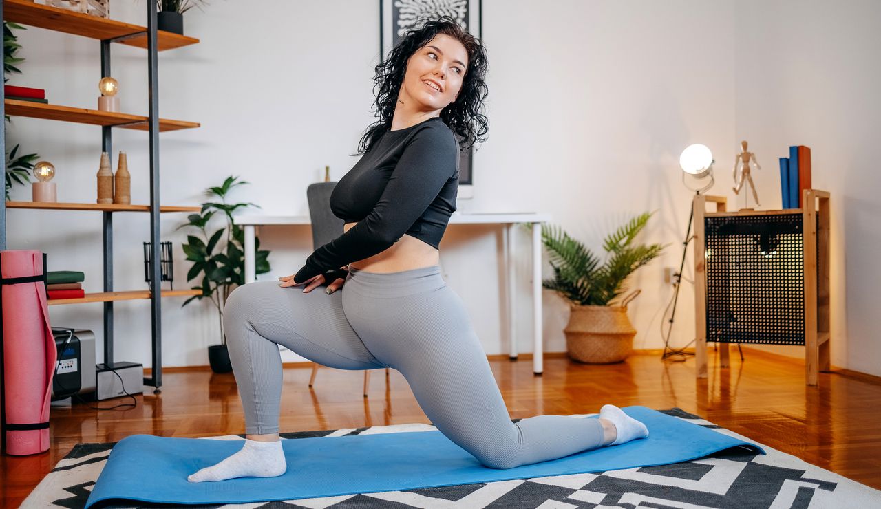 Woman doing hip stretch on yoga mat