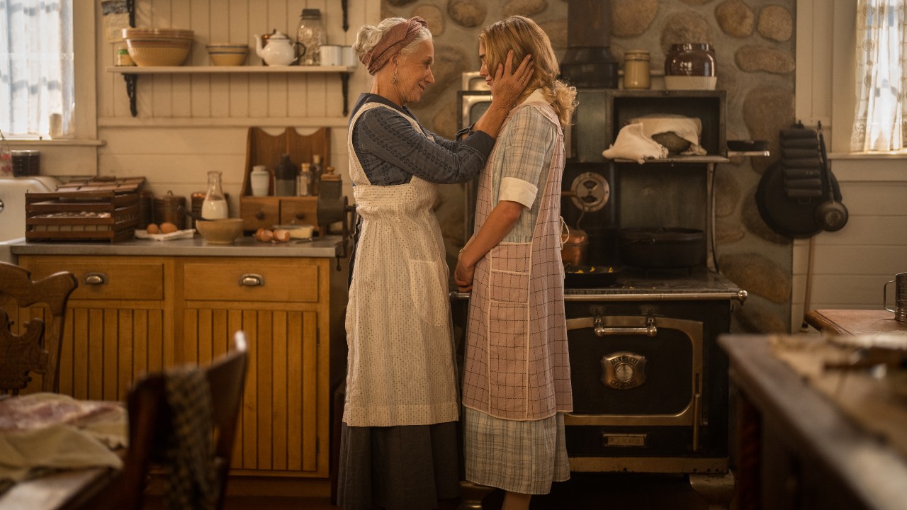 Helen Mirren as Cara holding Michelle Randolph's face as Elizabeth as they stand in the kitchen.