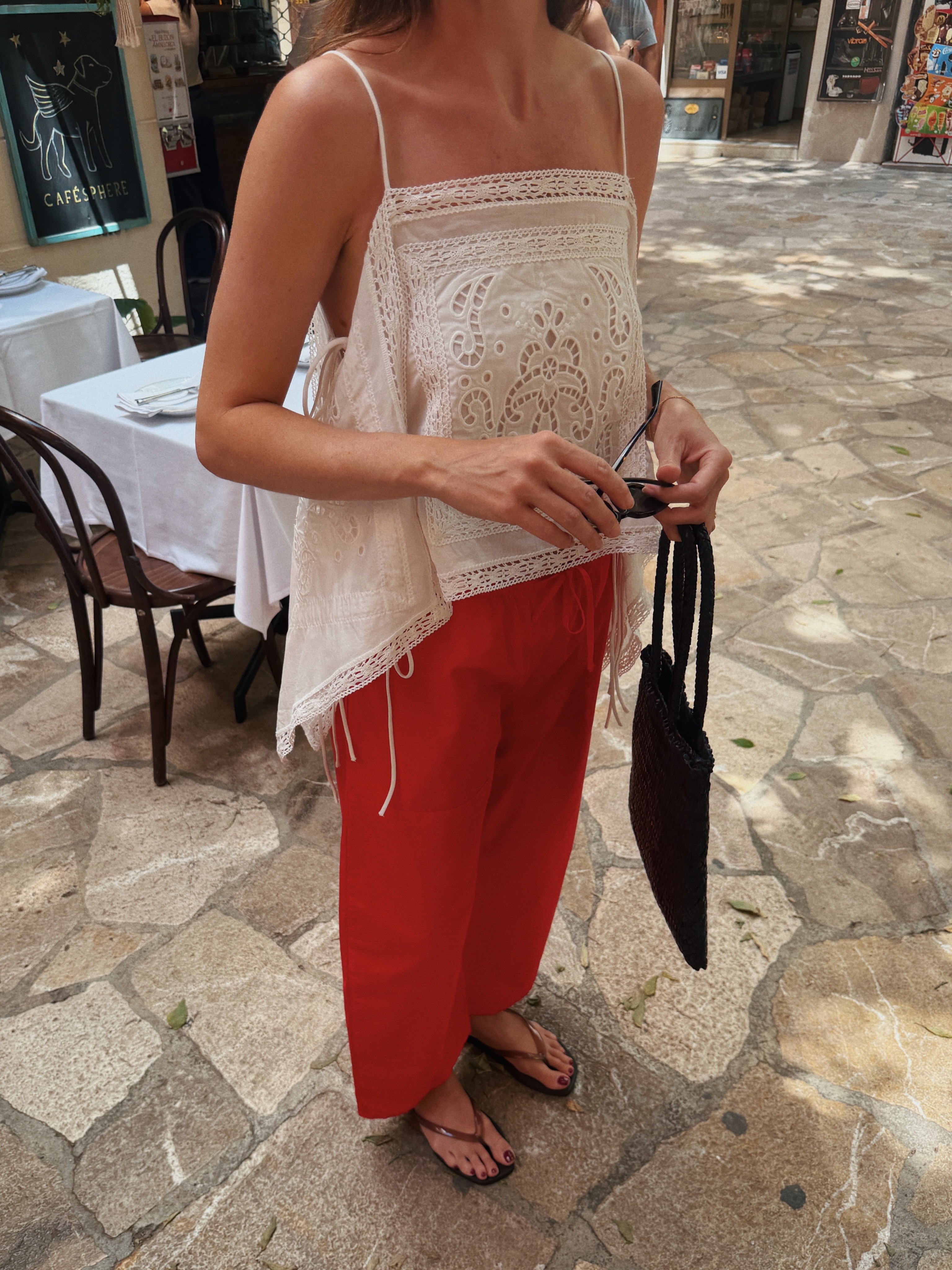 Woman in a white top and red pants.