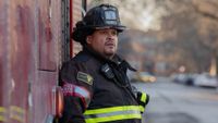 Cruz standing against the engine in his turnout gear on Chicago Fire.
